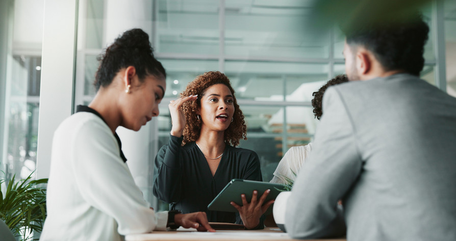 Menschen diskutieren auf der Arbeit an einem Tisch | Mandatsrentabilität steigern