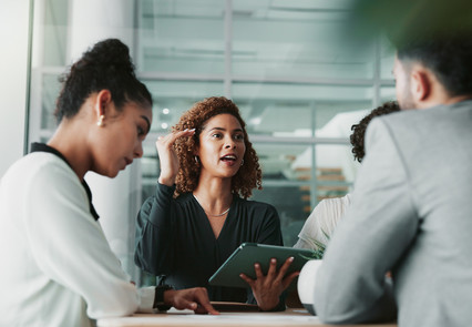 Menschen diskutieren auf der Arbeit an einem Tisch | Mandatsrentabilität steigern