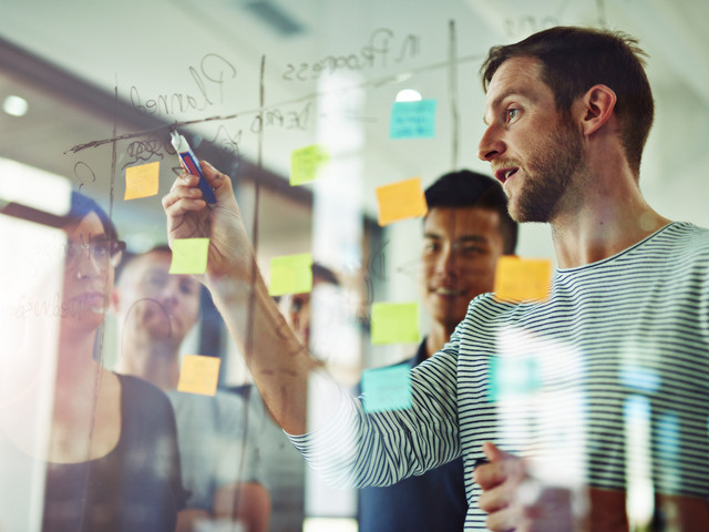 Mann vor Projektplanungstafel mit Post-ITs